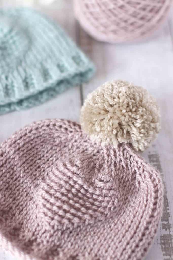 Tunisian crochet baby hat. Pink hat with beige pom pom.