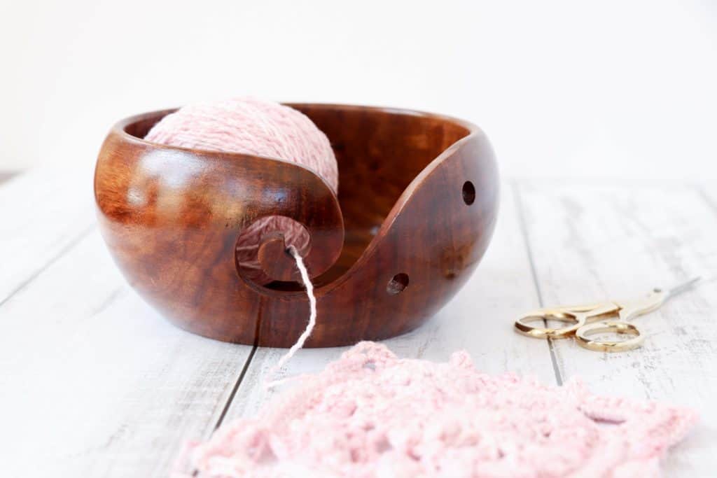 Yarn bowl with pink yarn and scissors