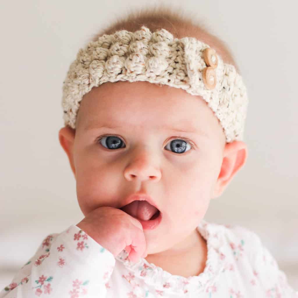 Crochet baby bobble headband, gorgeous baby girl wearing a neutral colored crochet headband with wooden buttons.
