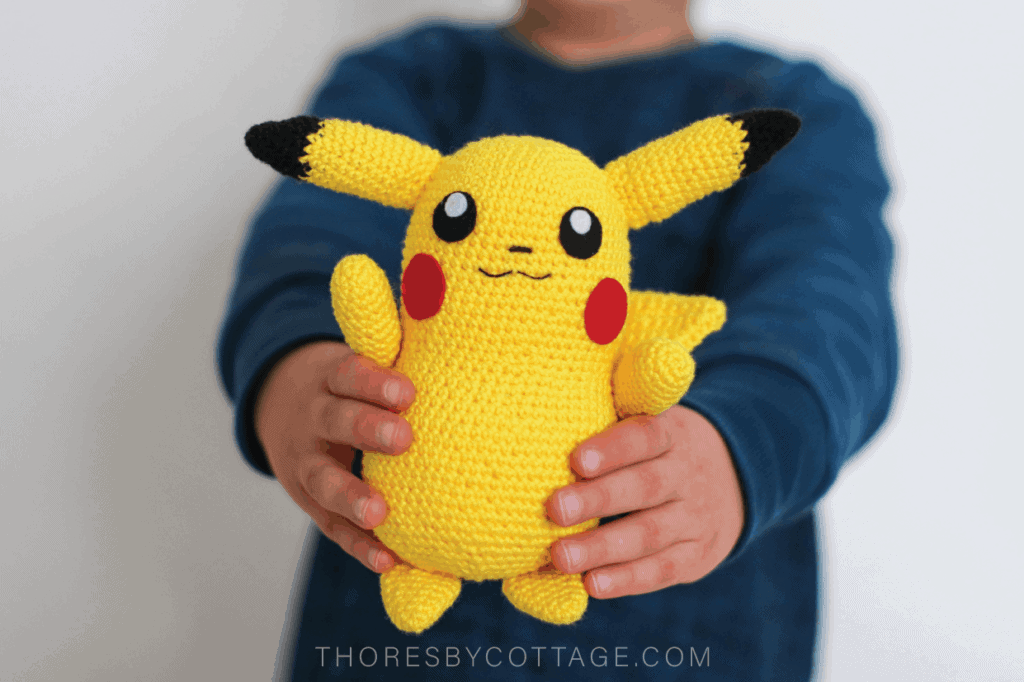Crochet Pikachu held forward by an excited child