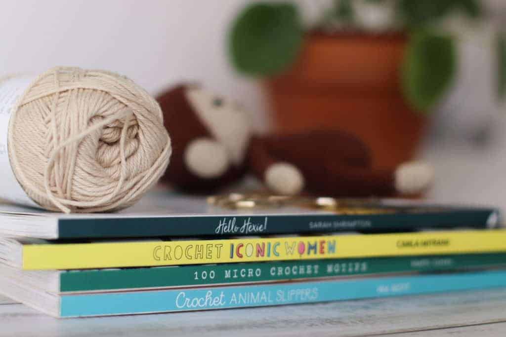 pile of crochet books and crochet cotton yarn