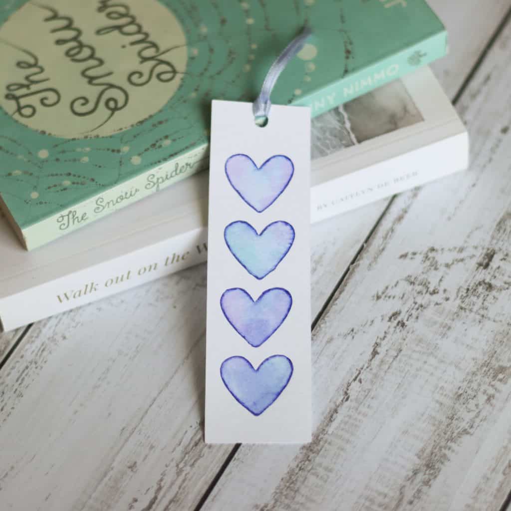 how to use Cricut watercolor markers to make a bookmark with purple hearts.