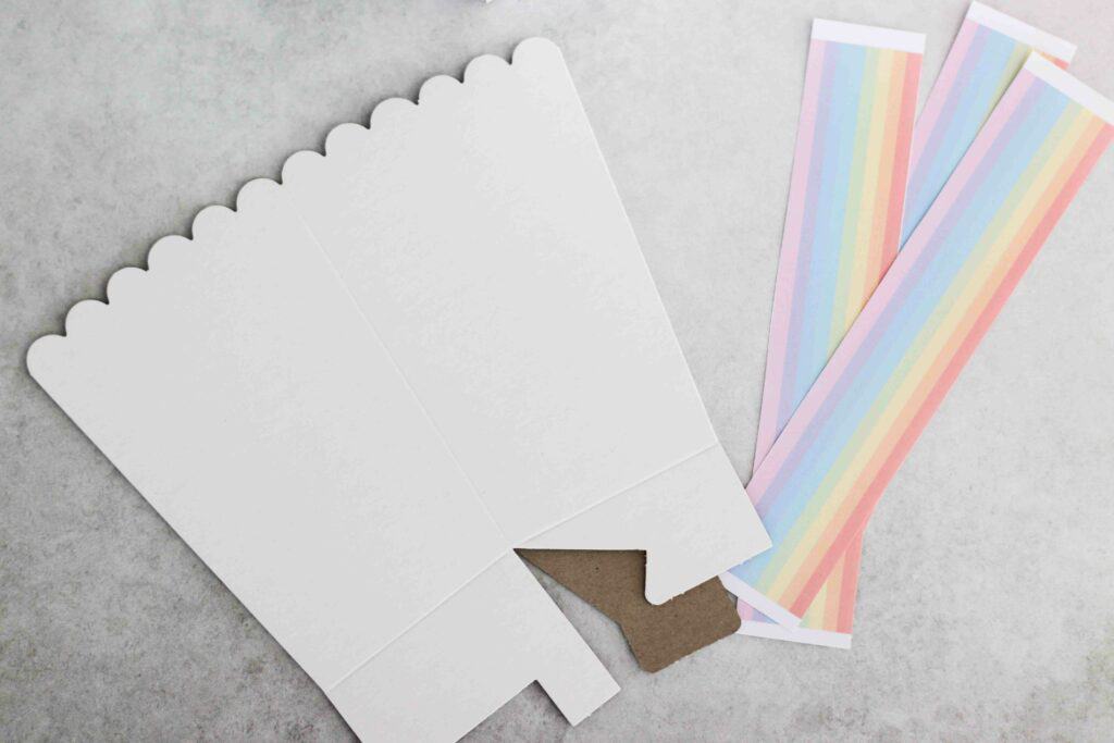 Requirements for DIY rainbow party bags include a cardboard popcorn box and rainbow handles