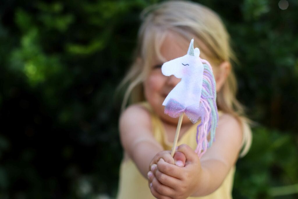 Young child holding a DIY unicorn wand